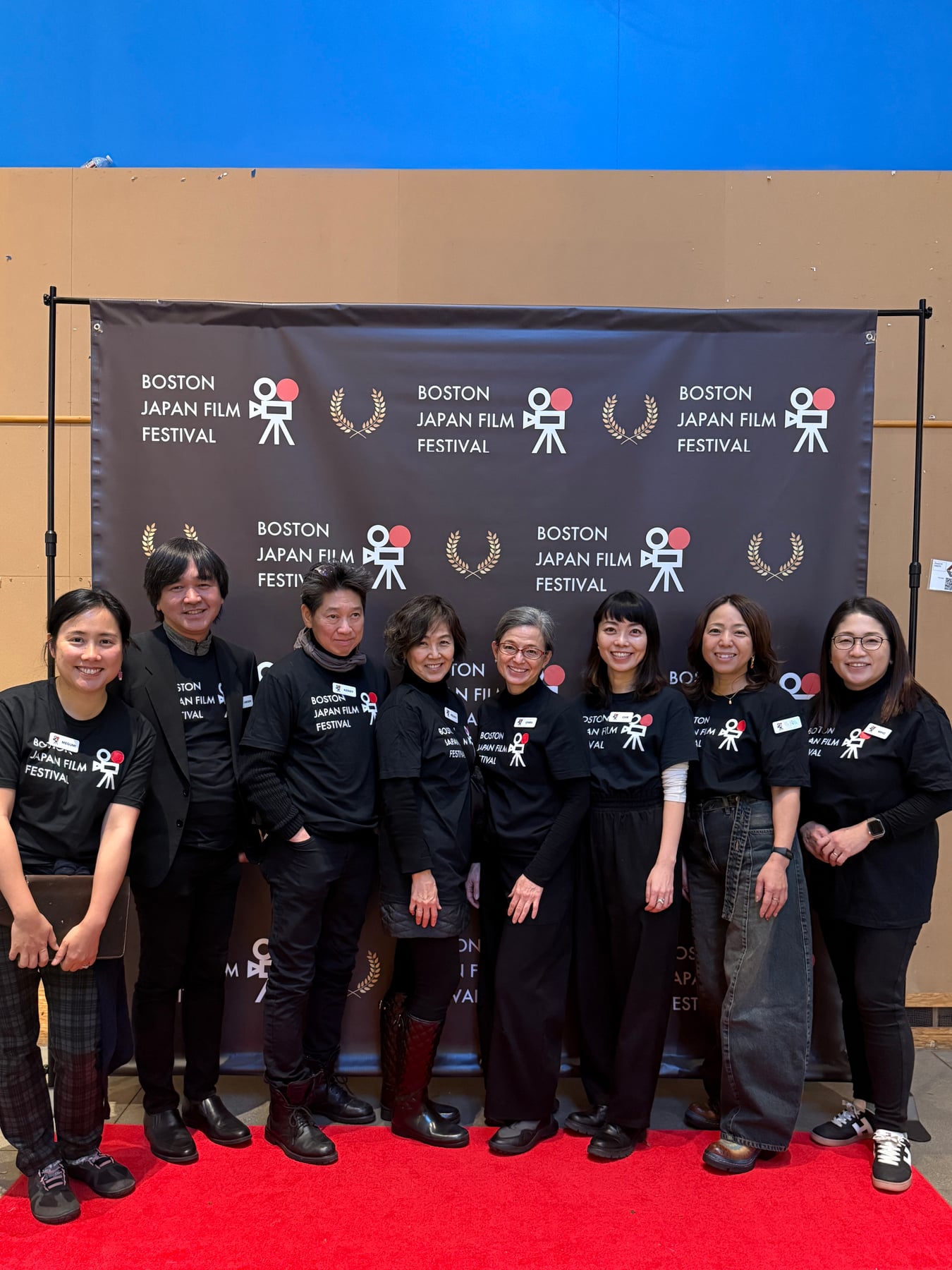 Eight people standing together on the red carpet in front of the Boston Japan Film Festival backdrop.